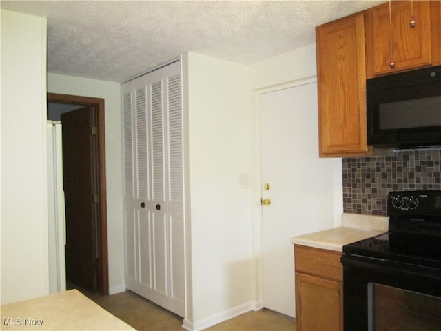 kitchen with a textured ceiling, black appliances, and backsplash