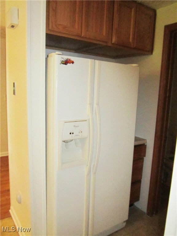 details with wood-type flooring and white refrigerator with ice dispenser