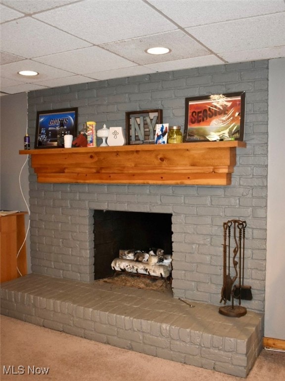 details with a paneled ceiling, carpet flooring, and a fireplace