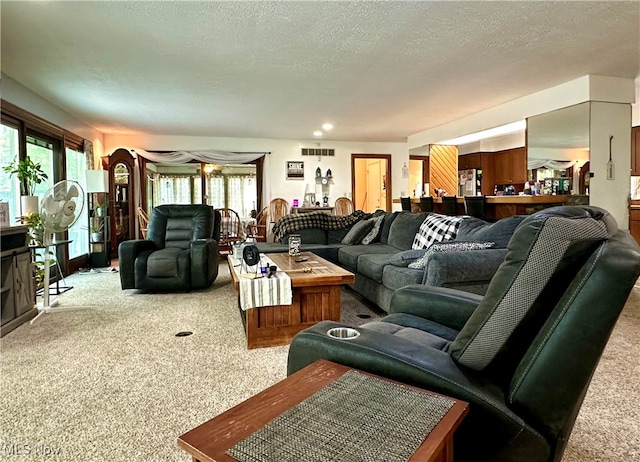 carpeted living room featuring a textured ceiling