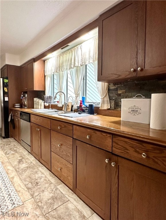 kitchen featuring tasteful backsplash, light tile patterned flooring, stainless steel appliances, and sink