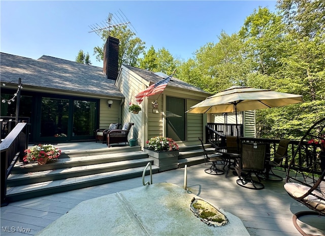 rear view of house featuring a wooden deck