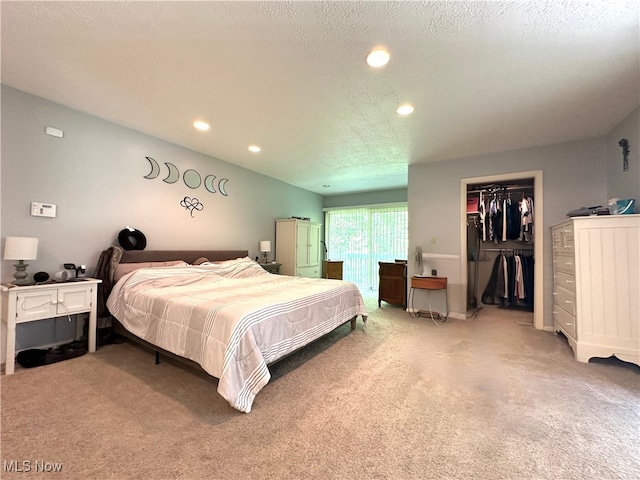 carpeted bedroom featuring a textured ceiling, a closet, and a spacious closet