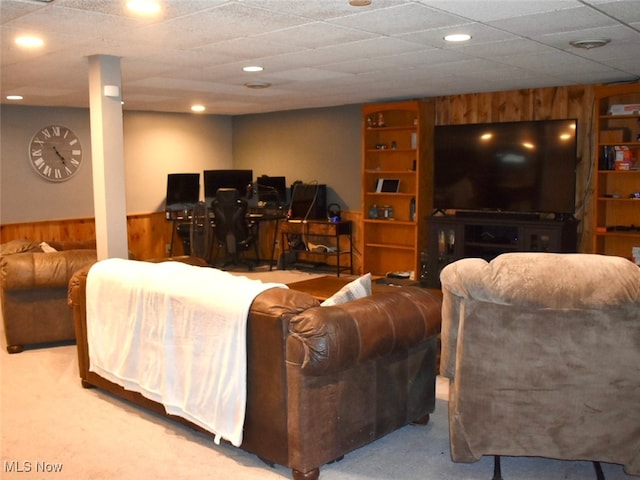 living room with a drop ceiling, light colored carpet, and built in features