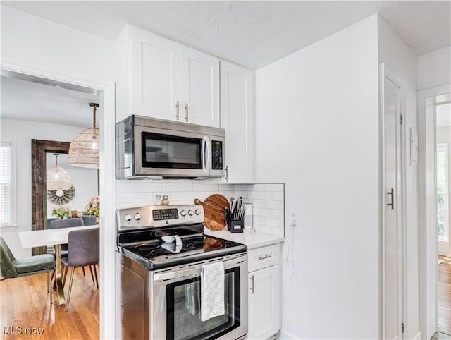 kitchen featuring white cabinetry, stainless steel appliances, and light countertops