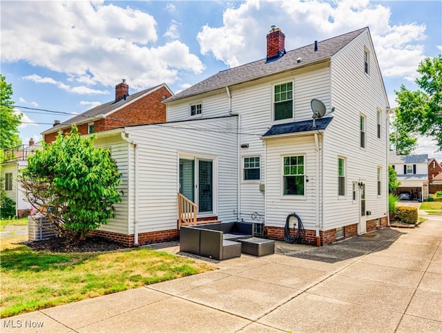 back of house featuring entry steps, an outdoor hangout area, a yard, a chimney, and a patio area