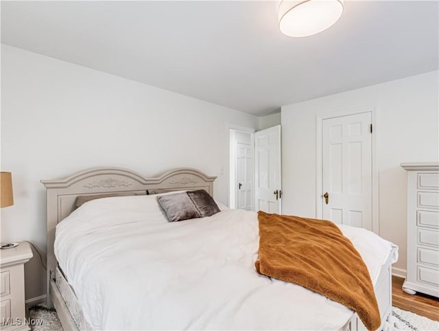 bedroom featuring light wood-style flooring and baseboards