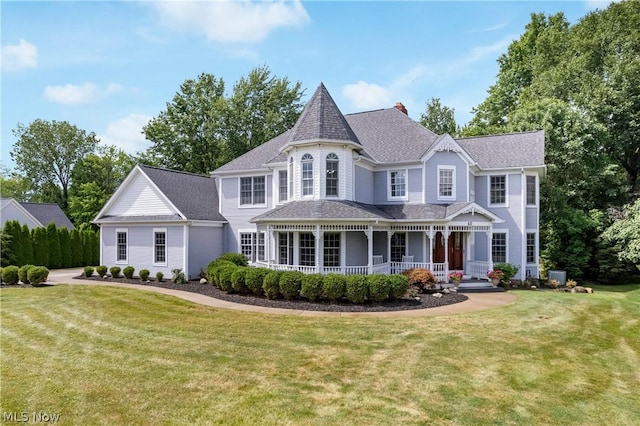 victorian house featuring central AC unit, a front lawn, and a porch