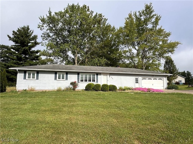 ranch-style house featuring a garage, driveway, and a front lawn