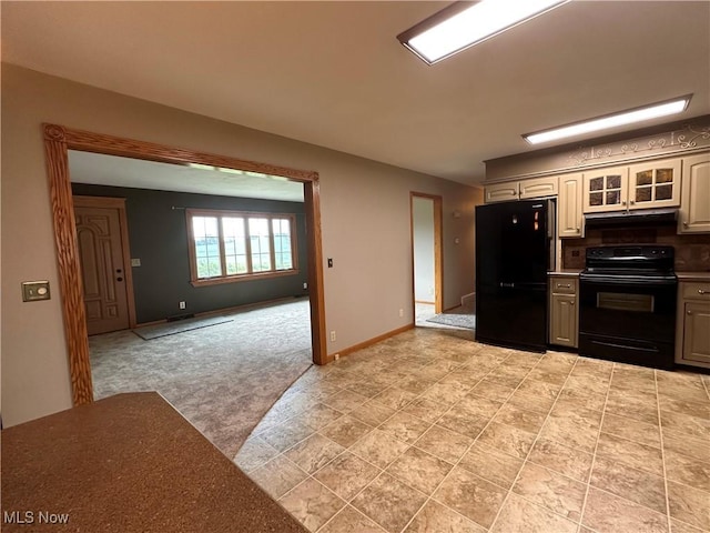 kitchen featuring black appliances, tasteful backsplash, glass insert cabinets, baseboards, and light colored carpet