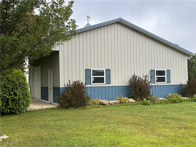 view of side of property featuring a garage and a yard