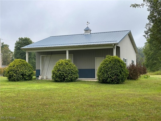 back of property with metal roof and a lawn