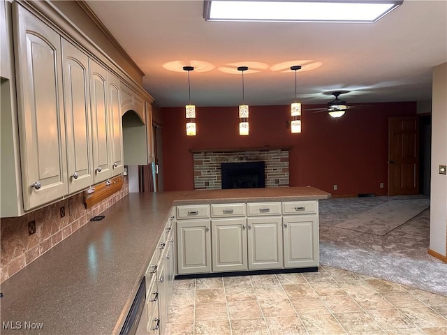 kitchen with tasteful backsplash, open floor plan, a peninsula, a fireplace, and hanging light fixtures