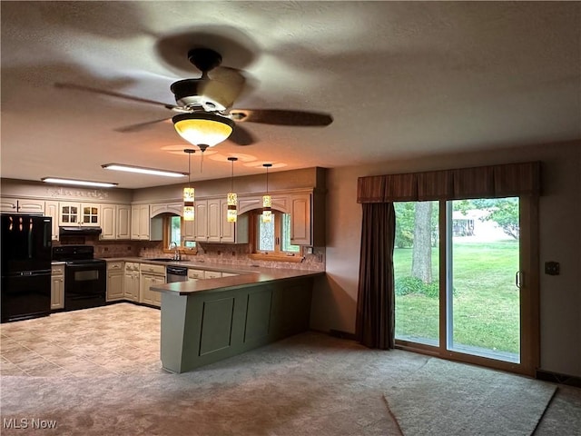 kitchen with a peninsula, black appliances, glass insert cabinets, under cabinet range hood, and backsplash