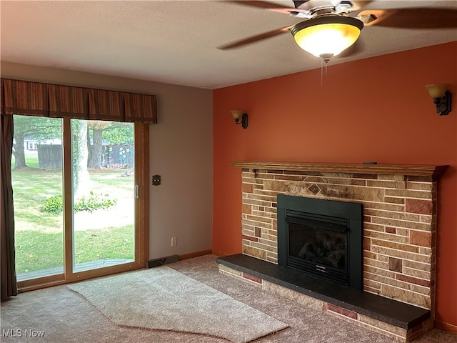 unfurnished living room featuring a brick fireplace, plenty of natural light, ceiling fan, and carpet flooring