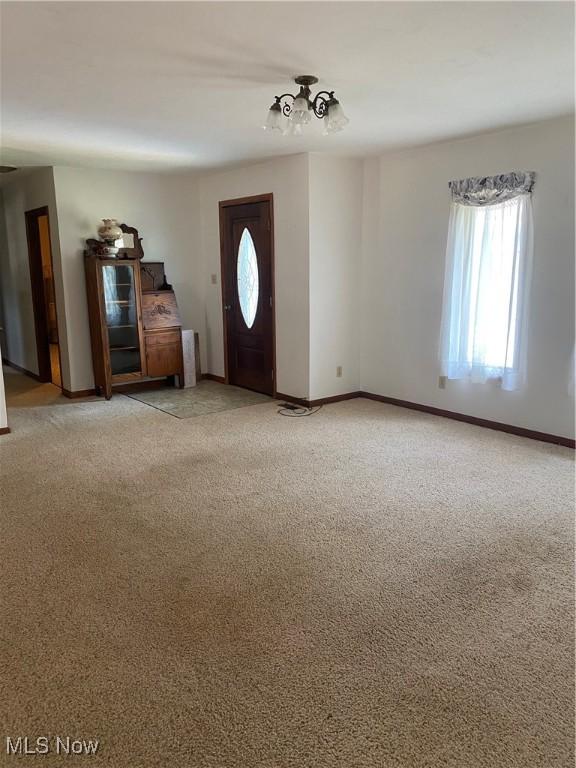 entrance foyer with light carpet and baseboards