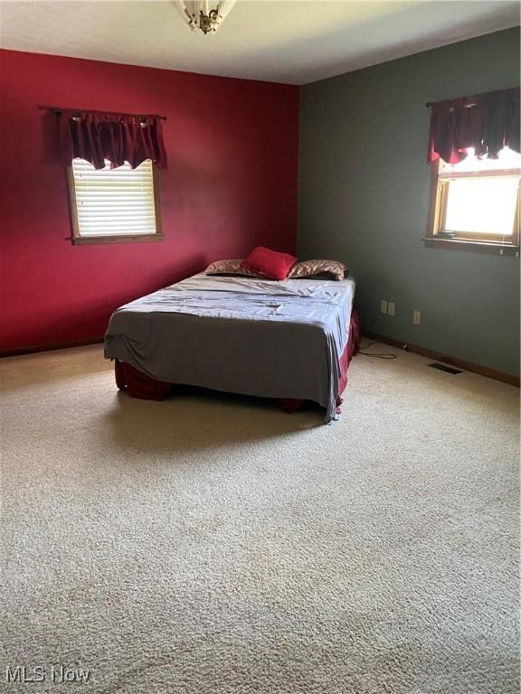 bedroom with baseboards and visible vents