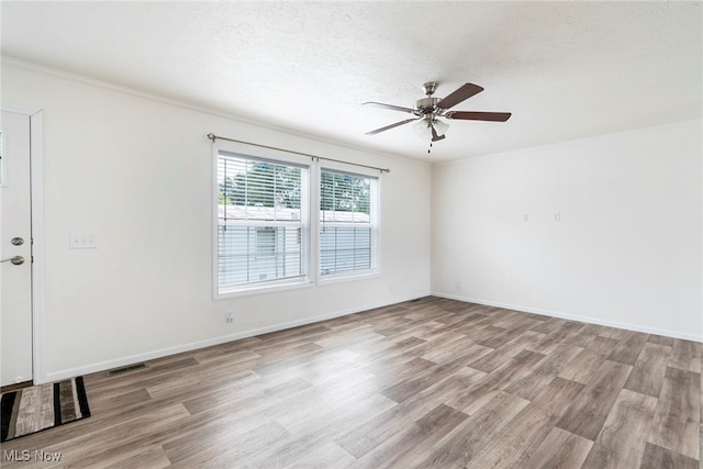 empty room featuring ceiling fan, light hardwood / wood-style flooring, and ornamental molding