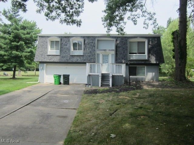 raised ranch with a garage and a front yard