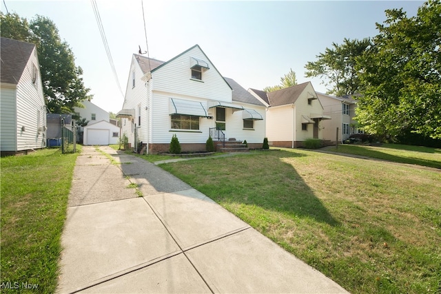 view of front of home with a garage, an outdoor structure, and a front yard