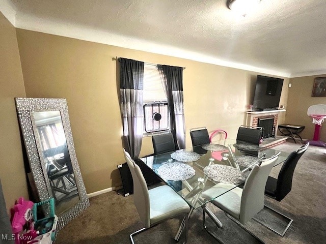 dining area featuring a textured ceiling, carpet flooring, and a fireplace