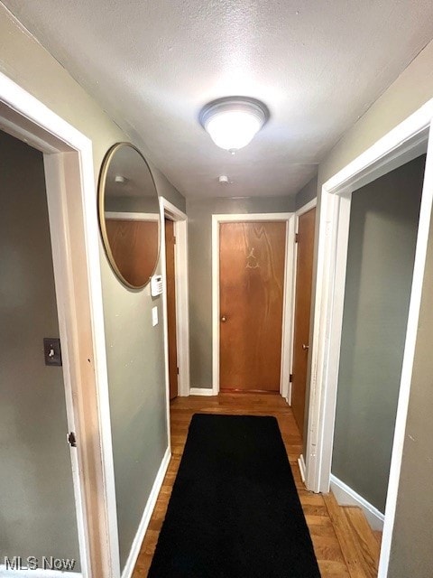 hallway featuring a textured ceiling and hardwood / wood-style floors