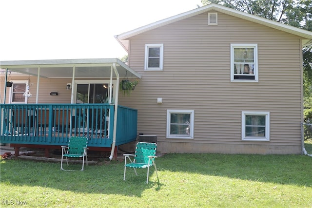 back of property featuring a yard and a deck