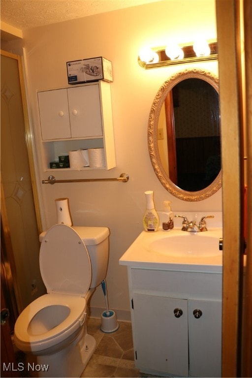 bathroom featuring vanity, a textured ceiling, toilet, and tile patterned flooring