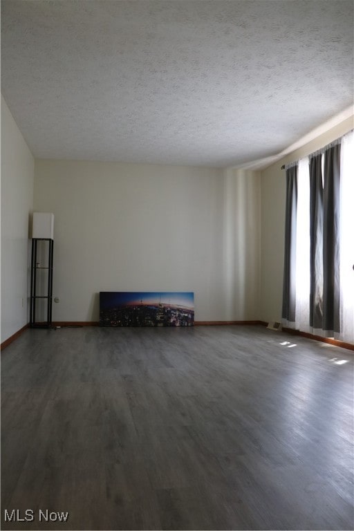 spare room with hardwood / wood-style floors and a textured ceiling