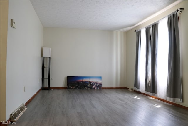 unfurnished living room featuring hardwood / wood-style floors and a textured ceiling