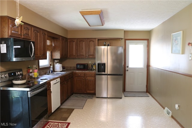 kitchen with sink, stainless steel appliances, and light tile patterned floors