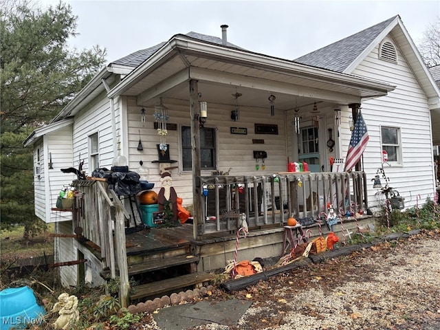 back of property featuring covered porch