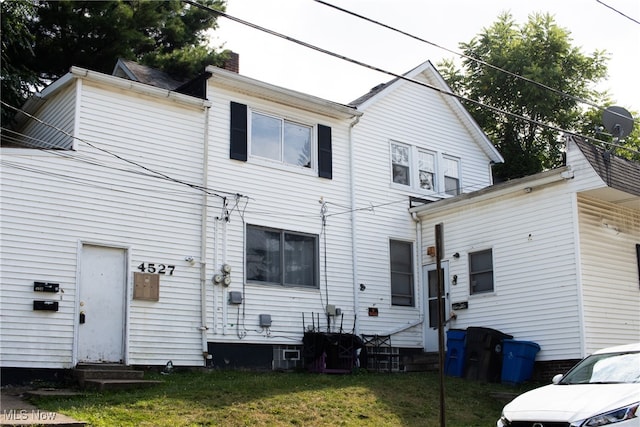 back of house featuring a lawn