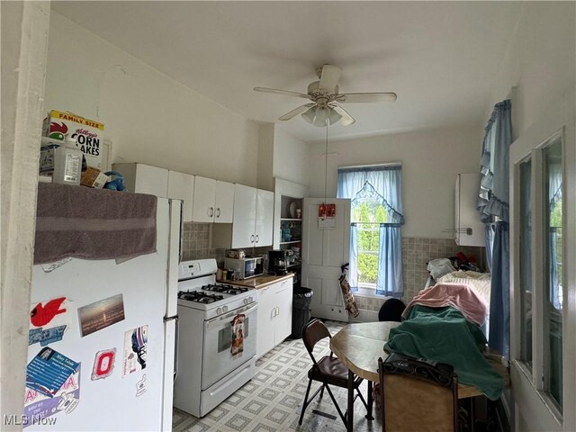 618 Market St, Clarington, OH 43915 - kitchen with white appliances, a ceiling fan, white cabinetry, light flooring, and backsplash