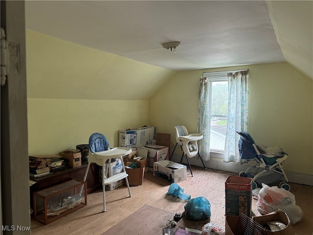 additional living space with vaulted ceiling and light hardwood / wood-style floors