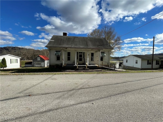 view of front of property with a porch and a storage shed