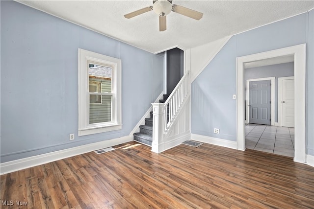 spare room with a textured ceiling, ceiling fan, and hardwood / wood-style floors