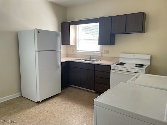 kitchen with sink, dark brown cabinets, washing machine and clothes dryer, and white appliances