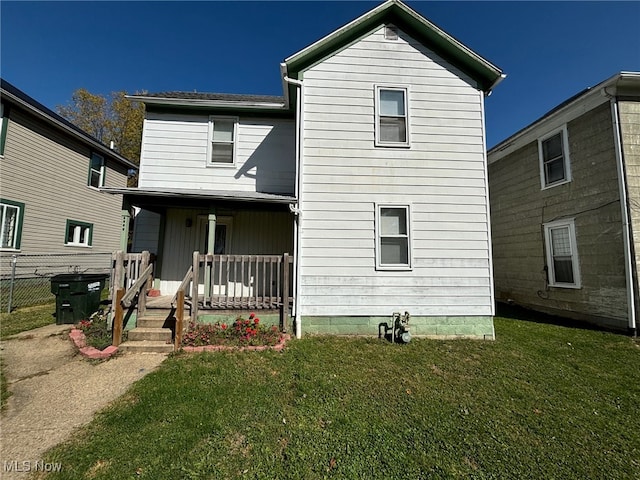 rear view of house featuring a yard