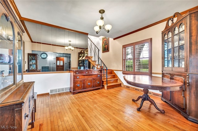 office space featuring an inviting chandelier, light hardwood / wood-style flooring, and ornamental molding