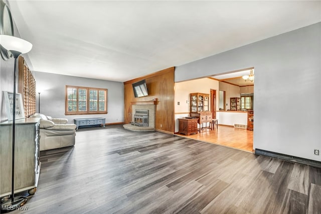 unfurnished living room featuring a notable chandelier, a fireplace, and hardwood / wood-style floors