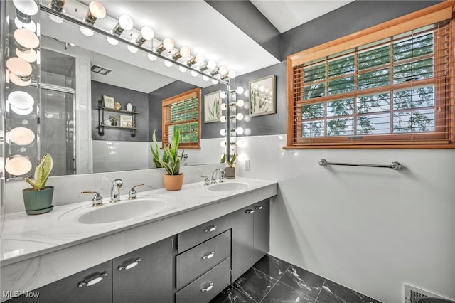 bathroom with tile patterned floors and dual bowl vanity