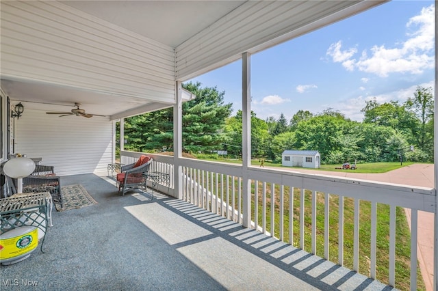 view of patio / terrace with covered porch, an outbuilding, and ceiling fan