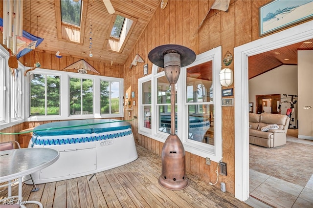 sunroom featuring wooden ceiling and lofted ceiling with skylight