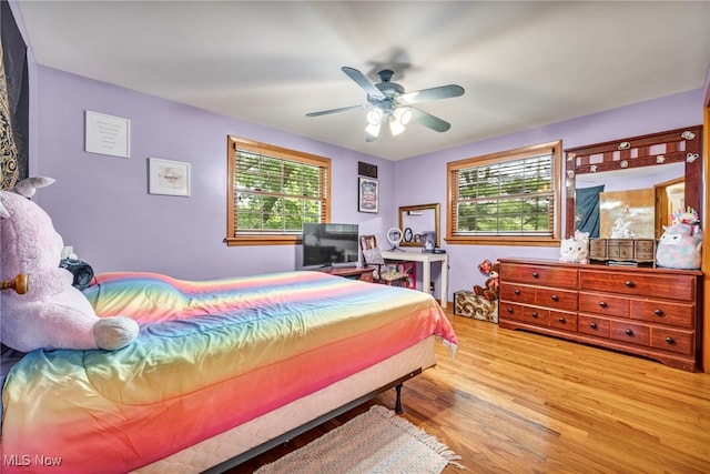 bedroom with light hardwood / wood-style floors, multiple windows, and ceiling fan