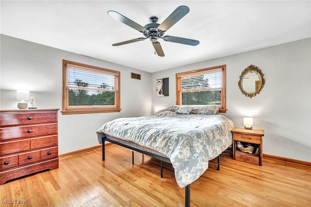 bedroom featuring multiple windows, light wood-type flooring, and ceiling fan