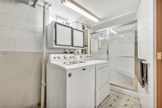 washroom with washer and clothes dryer, cabinets, and light tile patterned floors