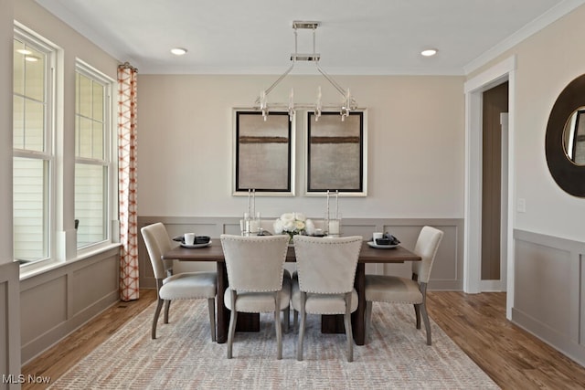 dining space with hardwood / wood-style flooring and crown molding