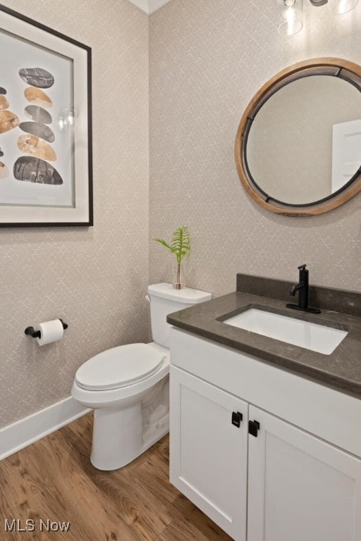 bathroom with wood-type flooring, toilet, and vanity