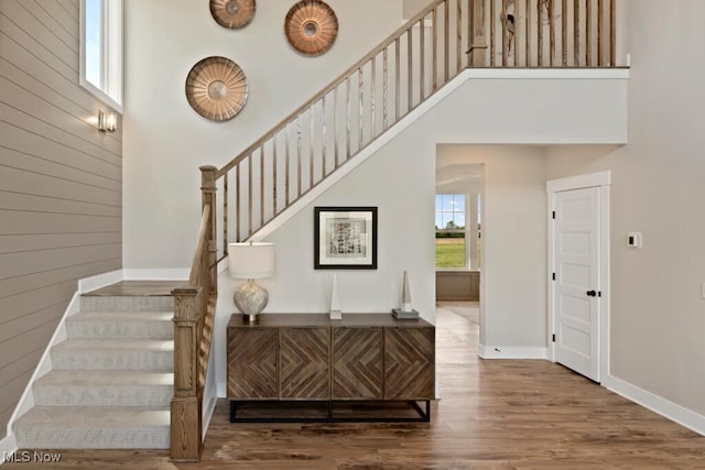 stairs featuring hardwood / wood-style flooring and a high ceiling